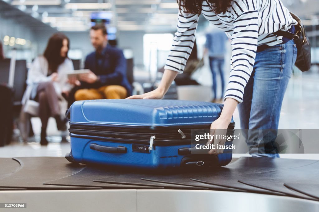Weiblichen Reisenden Abholung Koffer vom Gepäck Anspruch Linie