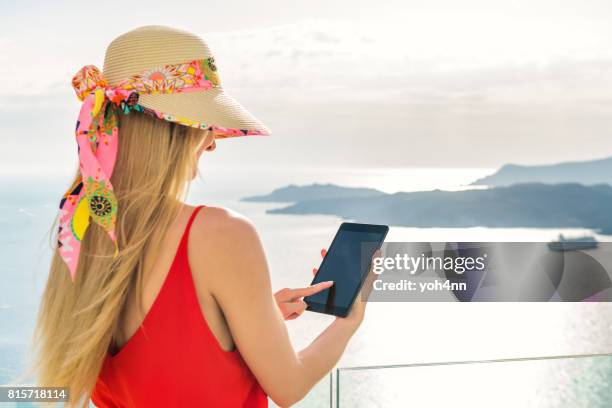 woman with tablet & volcano in santorini - passenger craft stock pictures, royalty-free photos & images