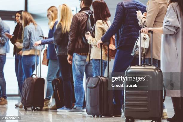 groupe de personnes debout dans la file d’attente à la porte d’embarquement - airline photos et images de collection