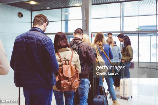 mensen staan in de wachtrij aan boord vliegtuig - mensen op een rij stockfoto's en -beelden