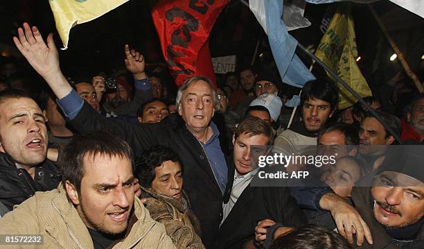 Former Argentina's president Nestor Kirchner arrives at the Plaza de Mayo surrounded by supporters during a demonstration backing the government's...