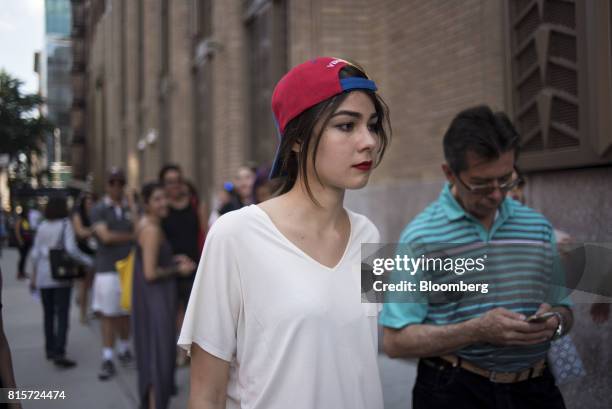 Venezuelan citizens living in the United States wait outside of a polling station to cast their ballots during a symbolic plebiscite in New York,...