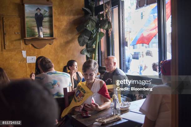 Venezuelan citizens living in the United States sit in a polling station after casting their ballots during a symbolic plebiscite in New York, U.S.,...