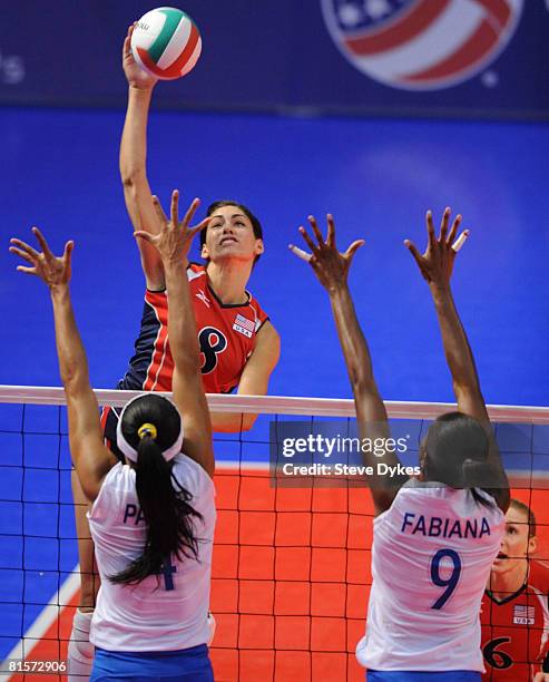 Cynthia Barboza of the USA spikes the ball on Paula Pequeno and Fabiana Claudino of Brazil during the volleyball game between the USA Women's...