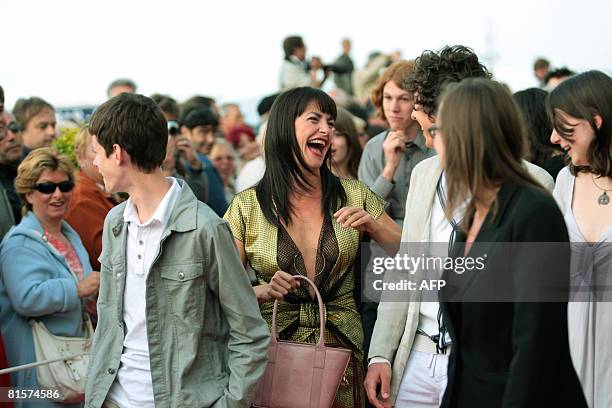 Belgian singer Lio gestures next to her children on the red carpet as they arrive at the 22nd Romantic Film festival ceremony in Cabourg,...