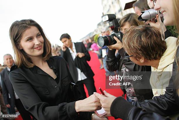 French actress Laetitia Casta signs autographs on the red carpet as she arrives at the 22nd Romantic Film festival ceremony in Cabourg, northwestern...