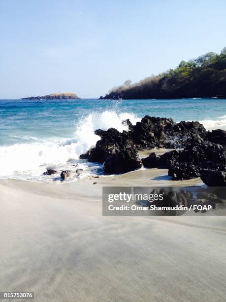 sea water splashing over the rock - omar shamsuddin stock-fotos und bilder