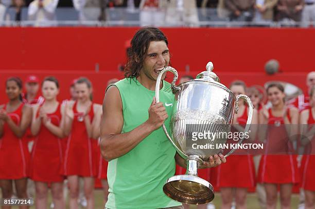 Spanish Rafael Nadal bites the trophy after winning the match against Serbian Novak Djokovic during the Final on day 7 of the Artois Championship...
