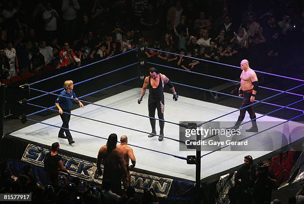 The Undertaker and ECW Champion Kane stand in the ring as the look down to Bam Neely, Chavo Guerrero, and The Great Khali during WWE Smackdown at...