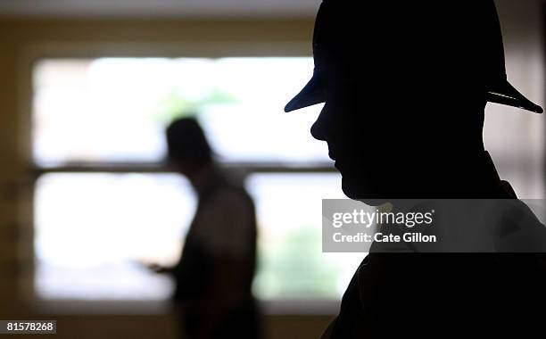 Police officer waits in the corridor while his colleague checks a refuse room during a search for stored knives in a tower block on June 13, 2008 in...