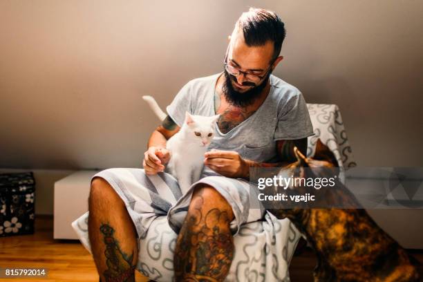 man cuddling with his cat and his dog - cat hipster no stock pictures, royalty-free photos & images