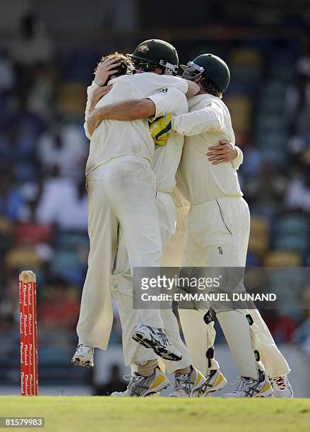 Australian bowler Beau Casson celebrates with teammates his first ever test wicket, taking out West Indies' batsman Xavier Marshall , during the...