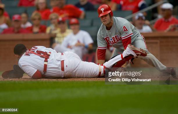 Eric Bruntlett of the Philadelphia Phillies reacts to being tagged out at home plate by Yadier Molina of the St. Louis Cardinals against at Busch...