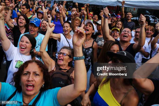 People raise their hands in celebration after voting during a symbolic Venezuelan plebiscite in Caracas, Venezuela, on Sunday, July 16, 2017....