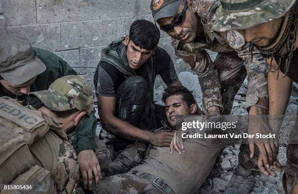 Iraqi special forces rescue a soldier of their battallion after he was wounded by an Islamic State sniper at the frontline in Mosul's Old City.