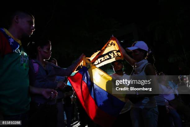 Venezuelan flag is displayed as people celebrate during a symbolic Venezuelan plebiscite in Caracas, Venezuela, on Sunday, July 16, 2017. Millions of...