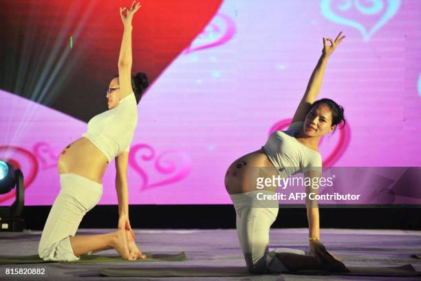 This photo taken on July 16, 2017 shows pregnant women doing yoga in a performance in Qingdao, in China's eastern Shandong province. A group of five...