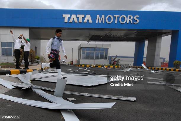 Security guards tries to restrict movements of guests, as sudden cyclonic winds disrupted the inauguration event of Tata Motors plant, causing major...