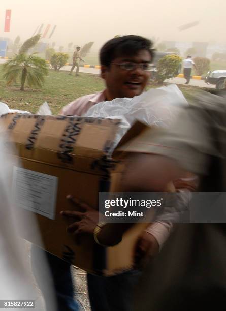 Guests try to take cover as sudden cyclonic winds disrupted the inauguration event of Tata Motors plant, causing major damage to the plant at Sanand,...