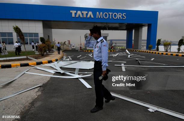 Security guards tries to restrict movements of guests, as sudden cyclonic winds disrupted the inauguration event of Tata Motors plant, causing major...