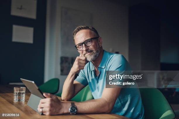 guapo de barba midaged en mesa con tableta digital - independiente fotografías e imágenes de stock