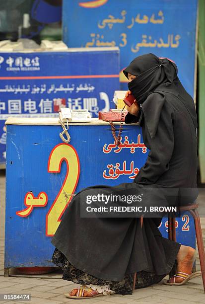 Uighur Muslim woman makes a phone call from publc phones available for 2rmb per minute at the Sunday Bazaar in Kashgar on June 15, 2008 in northwest...