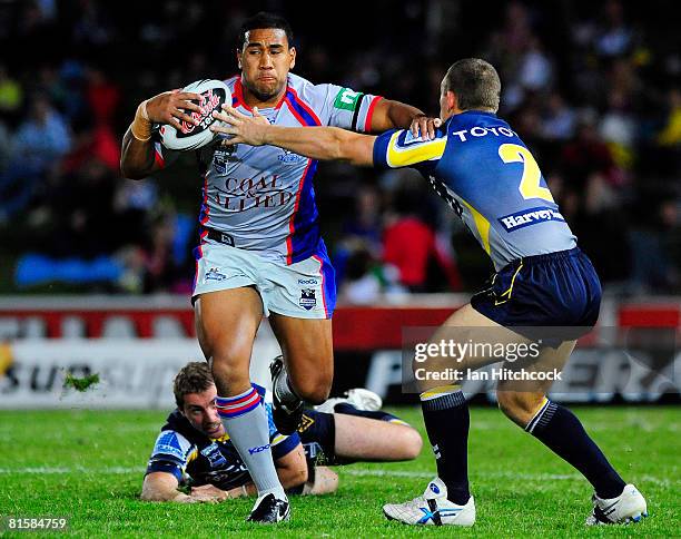 Cooper Vuna of the Knights looks to get past Mark Henry of the Cowboys during the round 14 NRL match between the North Queensland Cowboys and the...