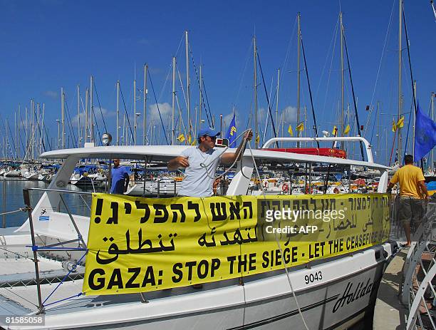 An Israeli captain stands in a boat decorated with a banner calling for an end of the blockade imposed by Israel on the Gaza Strip on June 16, 2008...