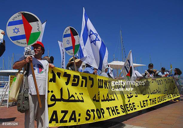 Israeli left wing activists hold a banner calling for an end of the blockade imposed by Israel on the Gaza Strip on June 16, 2008 at the marina in...