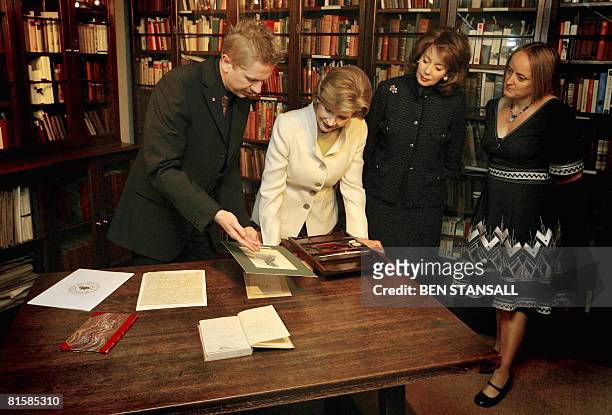 First Lady Laura Bush looks at work by Charles Dickens with Museum Director Andrew Xauier , wife of US Ambassador to Britain Maria Tuttle and...