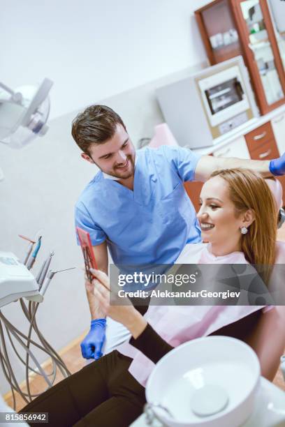 tandheelkunde patiënt controleren haar tanden na het tand schoonmaken in moderne kliniek - dental explorer stockfoto's en -beelden