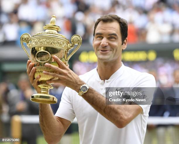 Roger Federer of Switzerland poses with his trophy after defeating Marin Cilic of Croatia in the Wimbledon men's singles final in London on July 16,...