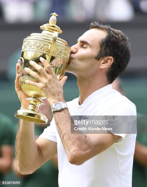 Roger Federer of Switzerland kisses his trophy after defeating Marin Cilic of Croatia in the Wimbledon men's singles final in London on July 16,...