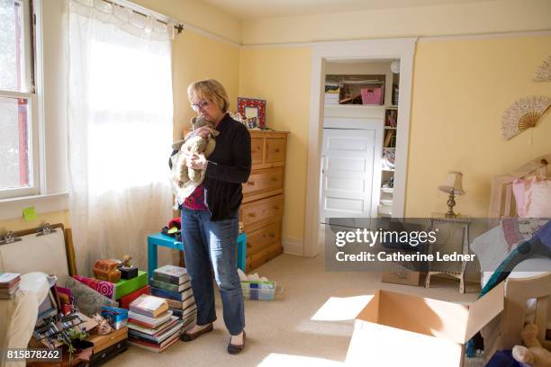 middle aged woman hugging daughter's childhood teddybear - old stuffed toy stock pictures, royalty-free photos & images