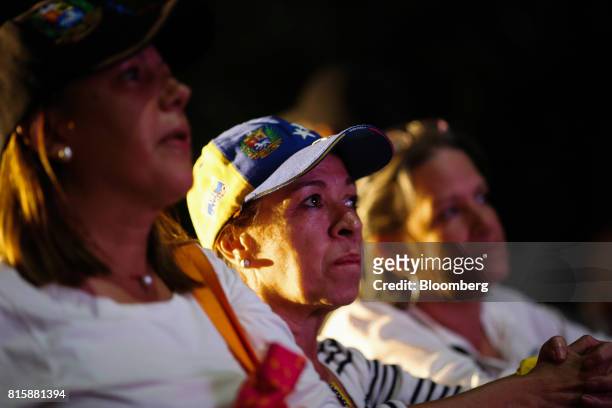People watch as partial results are announced during a symbolic Venezuelan plebiscite in Caracas, Venezuela, on Sunday, July 16, 2017. Millions of...