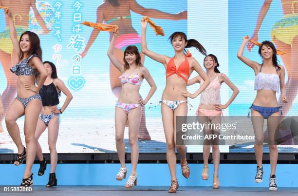 Models and dancers wearing new bikinis perform a promotional flash mob dance on stage in Tokyo on July 17, 2017. The event was organized by the Japan...