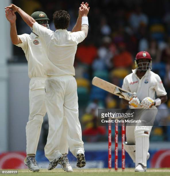 Beau Casson of Australia celebrates with team mate Phil Jaques after taking the wicket of Dwayne Bravo of the West Indies during day five of the...
