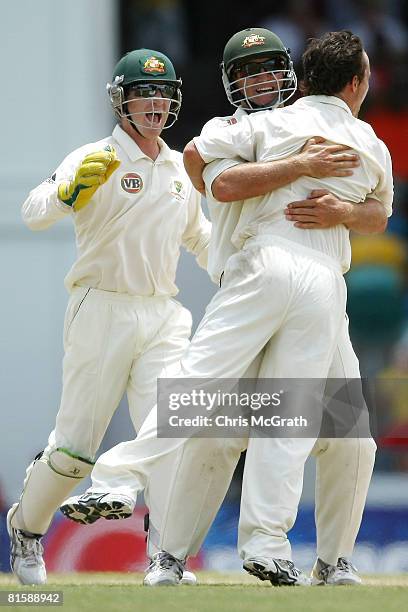 Beau Casson of Australia celebrates with team mate Phil Jaques and Brad Haddin after taking the wicket of Dwayne Bravo of the West Indies during day...