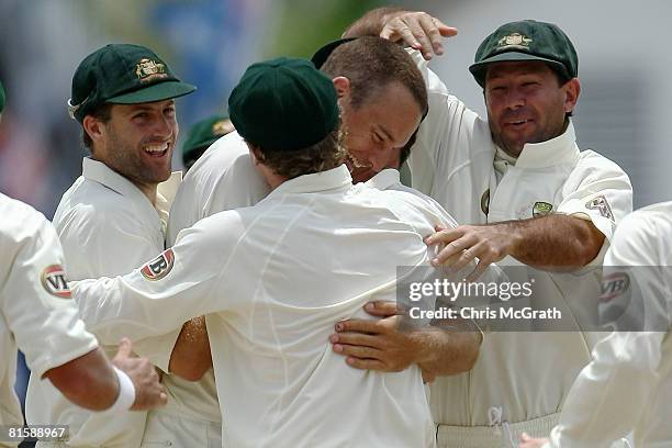 Stuart Clarke of Australia celebrate with team mates Simon Katich and Ricky Ponting after taking the wicket of Shivnarine Chanderpaul of the West...