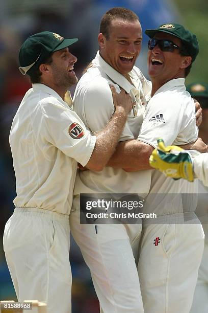 Stuart Clarke of Australia celebrate with team mates Simon Katich and Phil Jaques after taking the wicket of Shivnarine Chanderpaul of the West...