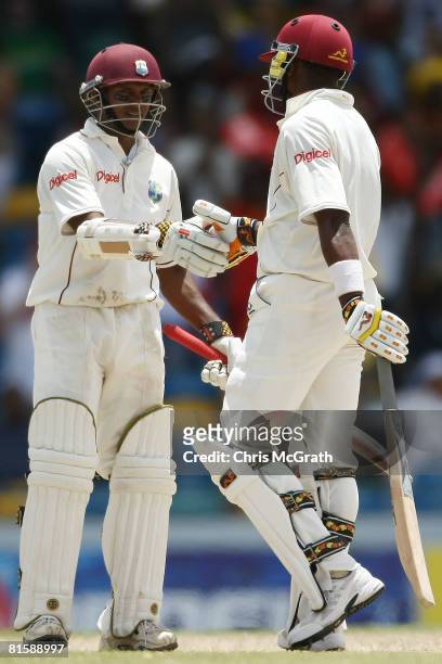 Dwayne Bravo of the West Indies congratulates team mate Shivnarine Chanderpaul after scoring his 8,000th test run during day five of the third test...
