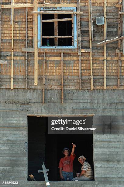 Palestinian laborers gesture from the window of a new building at a construction site in the religious neighborhood of Ramat Shlomo, the latest...