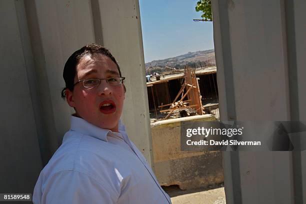 An ultra-Orthodox Jewish youth passes a construction site in the religious neighborhood of Ramat Shlomo, the latest Israeli development on land it...