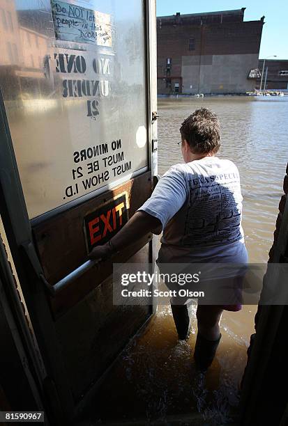 Nancy Jacobs wades out of her flooded South Side Inn bar June 16, 2008 in Burlington, Iowa. Communities along the Mississippi River in Iowa, Illinois...