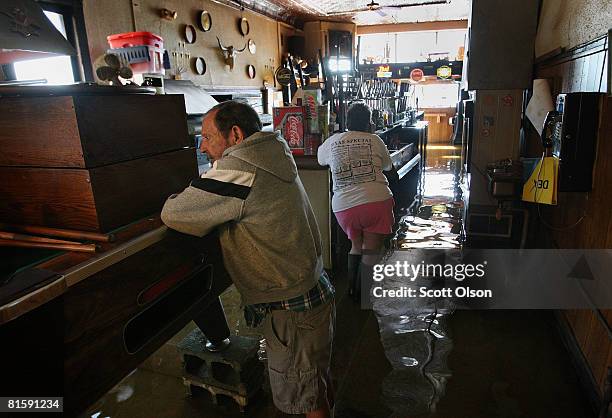 Warren and Nancy Jacobs stand inside their flooded South Side Inn bar June 16, 2008 in Burlington, Iowa. Communities along the Mississippi River in...