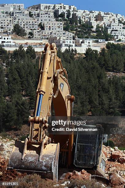 Hydraulic excavator breaks ground for a new section of Israel's separation barrier near the Jewish neighborhood of Ramat Shlomo, on June 16, 2008...