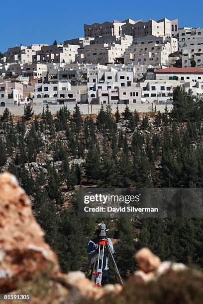 An Israeli surveyor checks the progress of ground-breaking work for a new section of Israel's separation barrier near the Jewish neighborhood of...