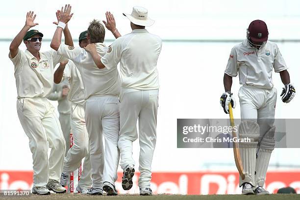 Michael Hussey of Australia and team mates congratulate Brett Lee after he took the final wicket of Daren Powell of the West Indies giving Australia...