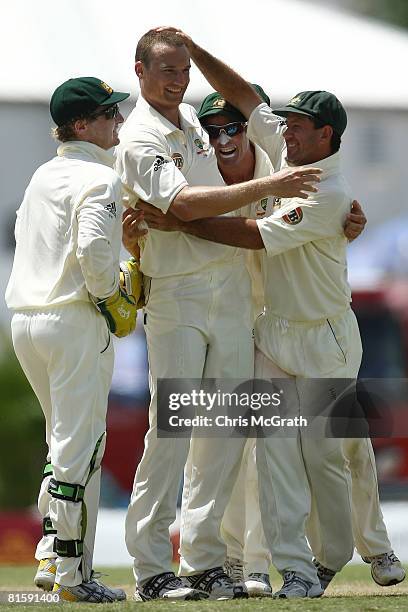 Stuart Clarke of Australia is congratulated by team mates Brad Haddin, Michael Hussey and Ricky Ponting after taking the wicket of Denesh Ramden of...