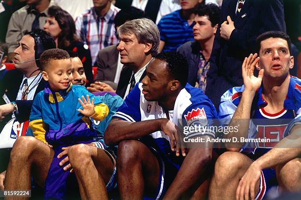 Dell Curry of the Charlotte Hornets and his son Stephen Curry sit with Mitch Richmond of the Sacramento Kings and Drazen Petrovic of the New Jersey...